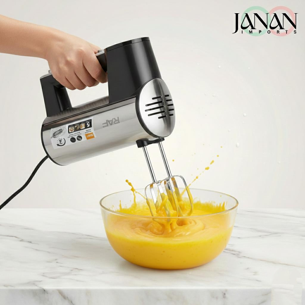Hand mixer being used to beat eggs in a bowl on a marble surface with Janan Imports branding.